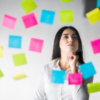 Business woman Glues stickers and thinking over the project